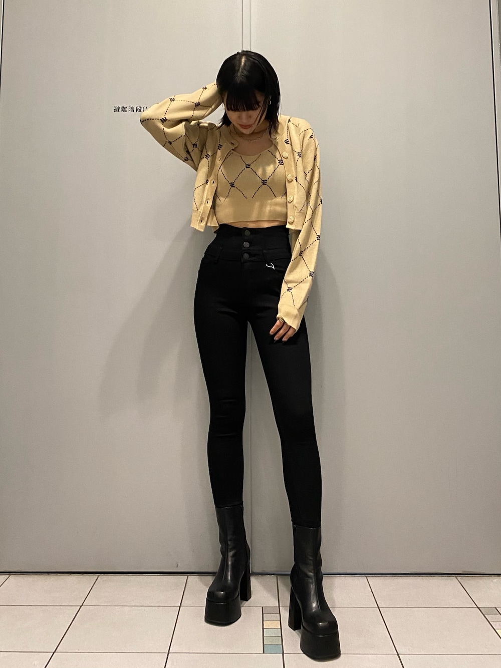 ブラック系のブーツ、ブラック系のデニムパンツ、ベージュ系のニット/セーターを着用したレディースの秋コーディネートの1枚目の写真