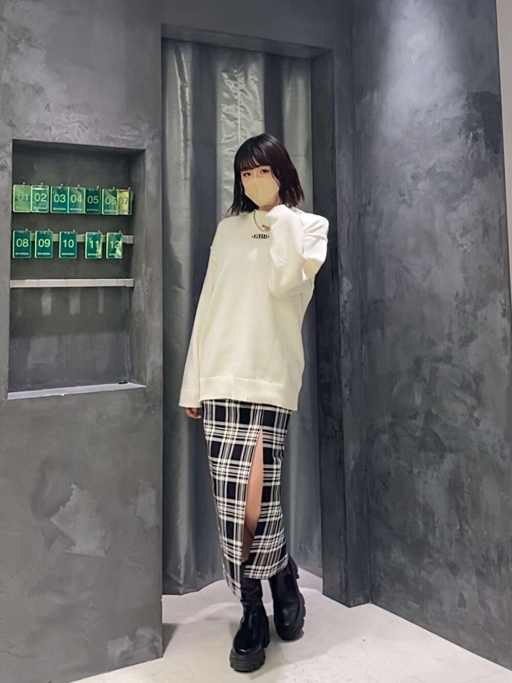 その他のスカート、ホワイト系のニット/セーター、ブラック系のブーツを着用したレディースの冬コーディネートの1枚目の写真