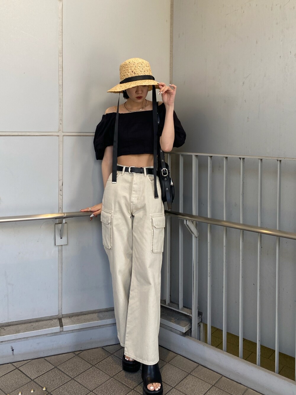 ブラック系のサンダル、ホワイト系のデニムパンツ、ブラック系のシャツ/ブラウスを着用したレディースの春コーディネートの1枚目の写真