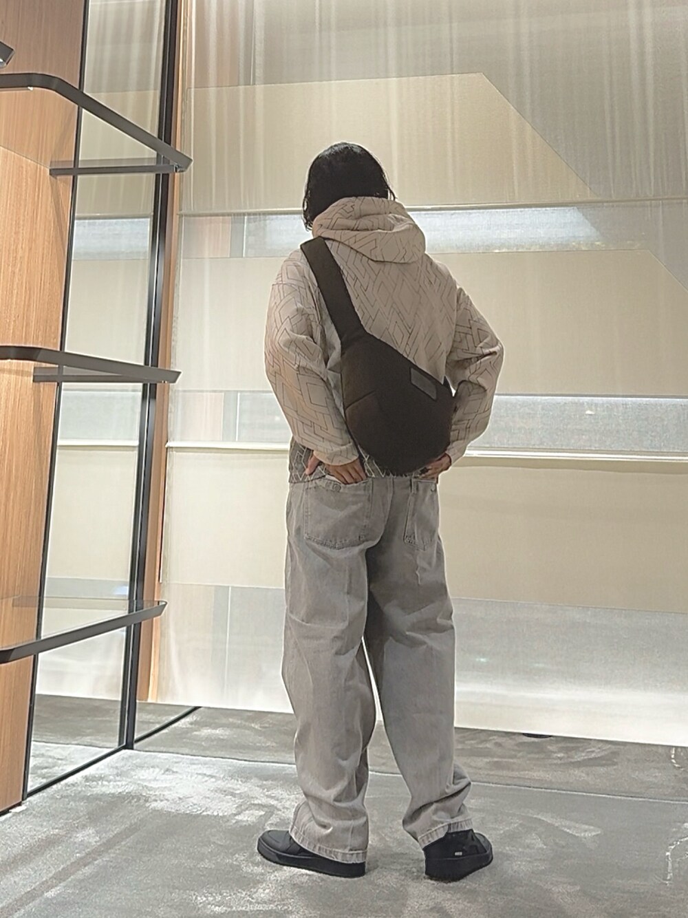 ブルー系のスウェット、グリーン系のショルダーバッグ、グレー系のデニムパンツを着用したメンズの秋コーディネートの1枚目の写真