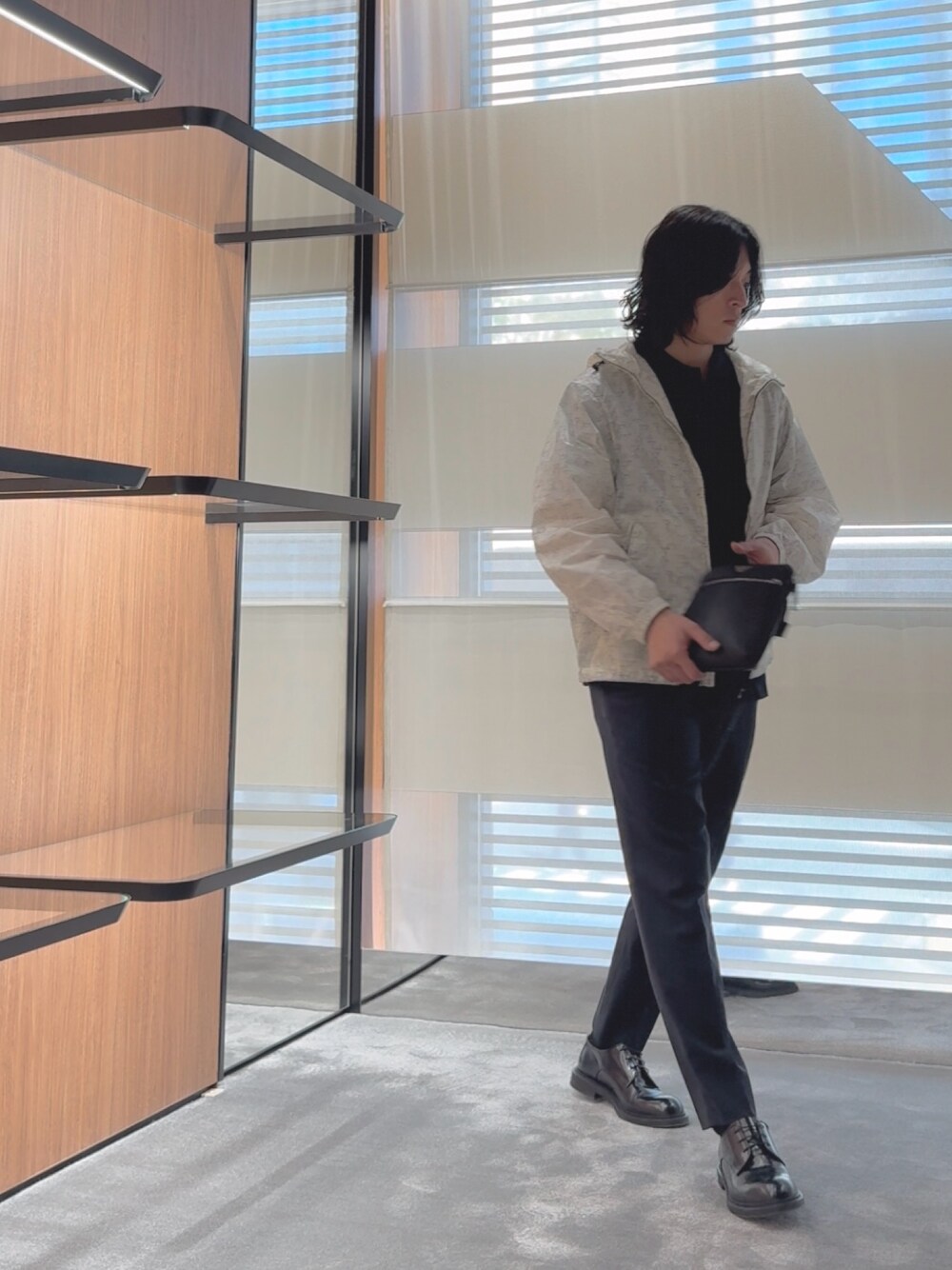 ブルー系のポロシャツ、ホワイト系のブルゾン、ブラック系のショルダーバッグを着用したメンズの春コーディネートの1枚目の写真