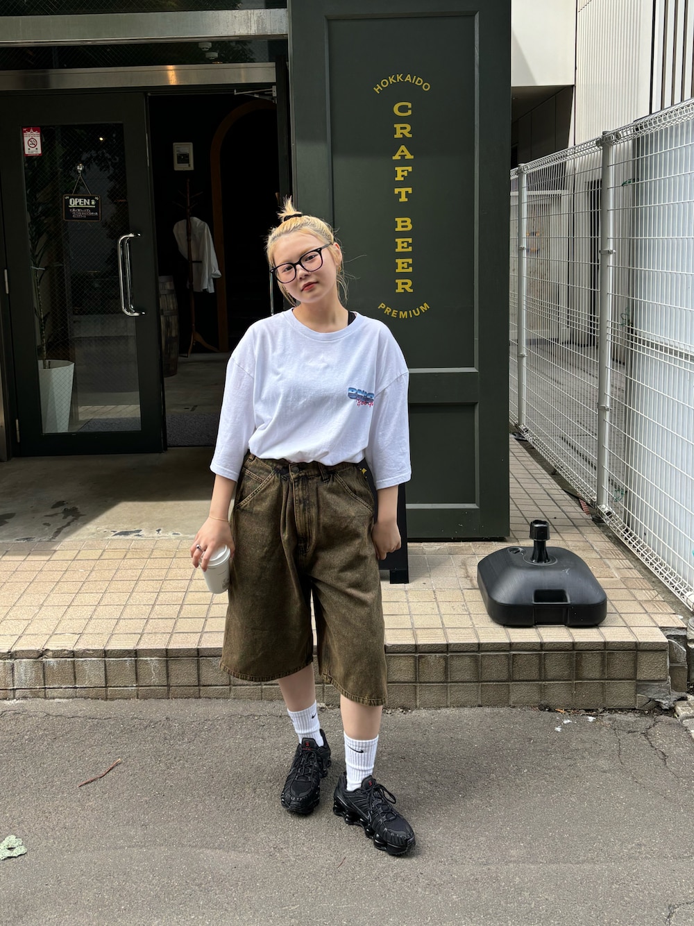 ホワイト系のTシャツ/カットソー、ブラウン系のデニムパンツを着用したレディースの夏コーディネートの1枚目の写真