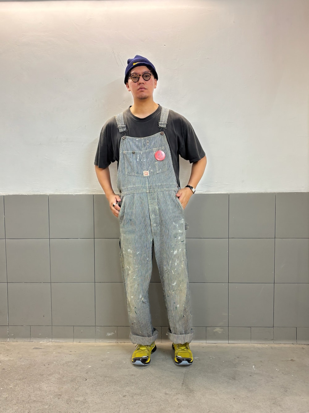 ブルー系のつなぎ/オールインワン、イエロー系のスニーカー、ブラック系のTシャツ/カットソーを着用したメンズの春コーディネートの1枚目の写真