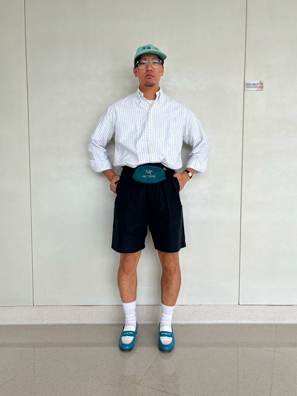 ブルー系のカーゴパンツ、ブルー系のボディバッグ/ウエストポーチ、グリーン系のシャツ/ブラウスを着用したメンズの夏コーディネートの1枚目の写真