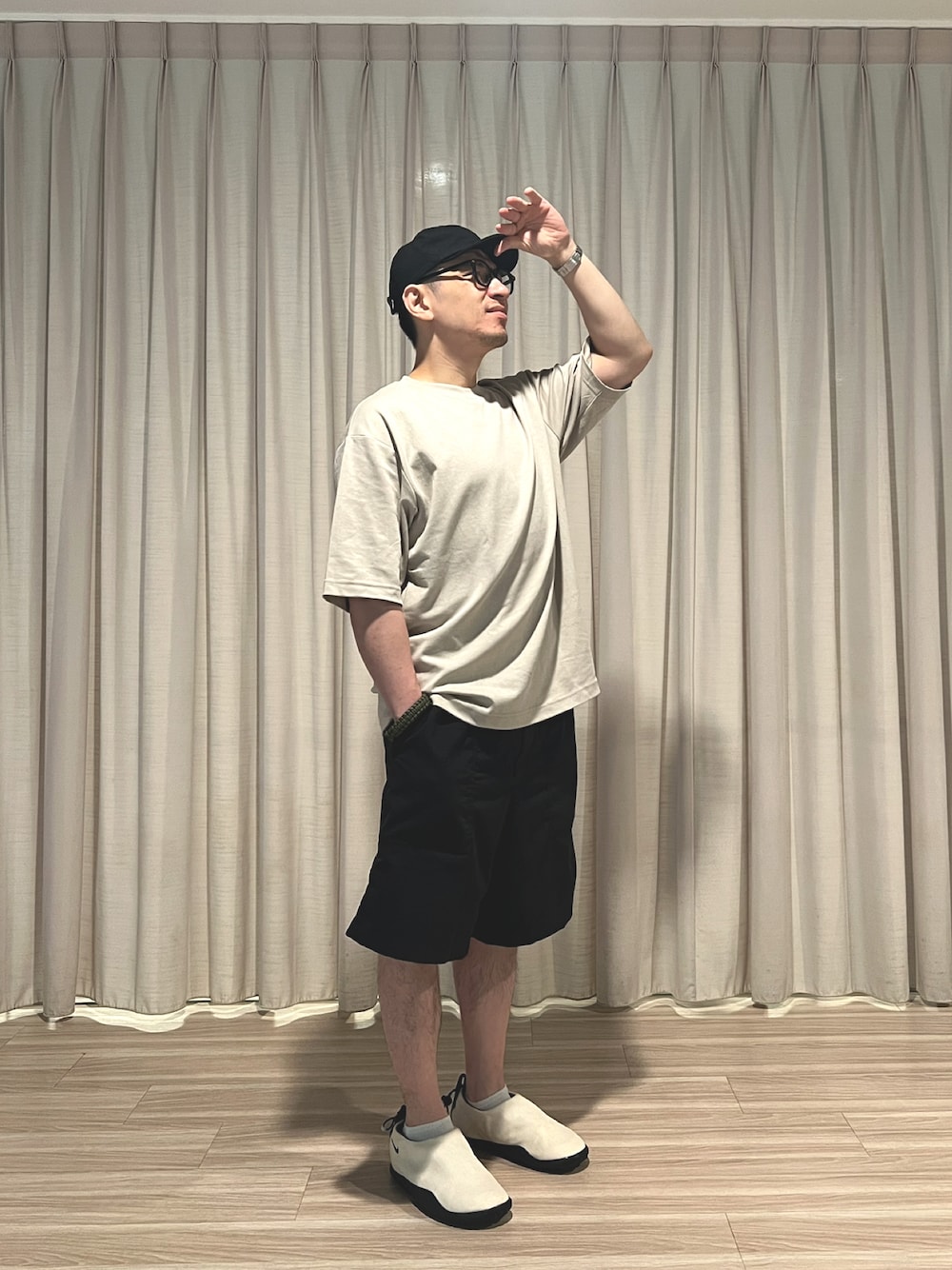 ベージュ系のTシャツ/カットソー、ブラック系のカーゴパンツ、ベージュ系のスリッポンを着用したメンズの秋コーディネートの1枚目の写真