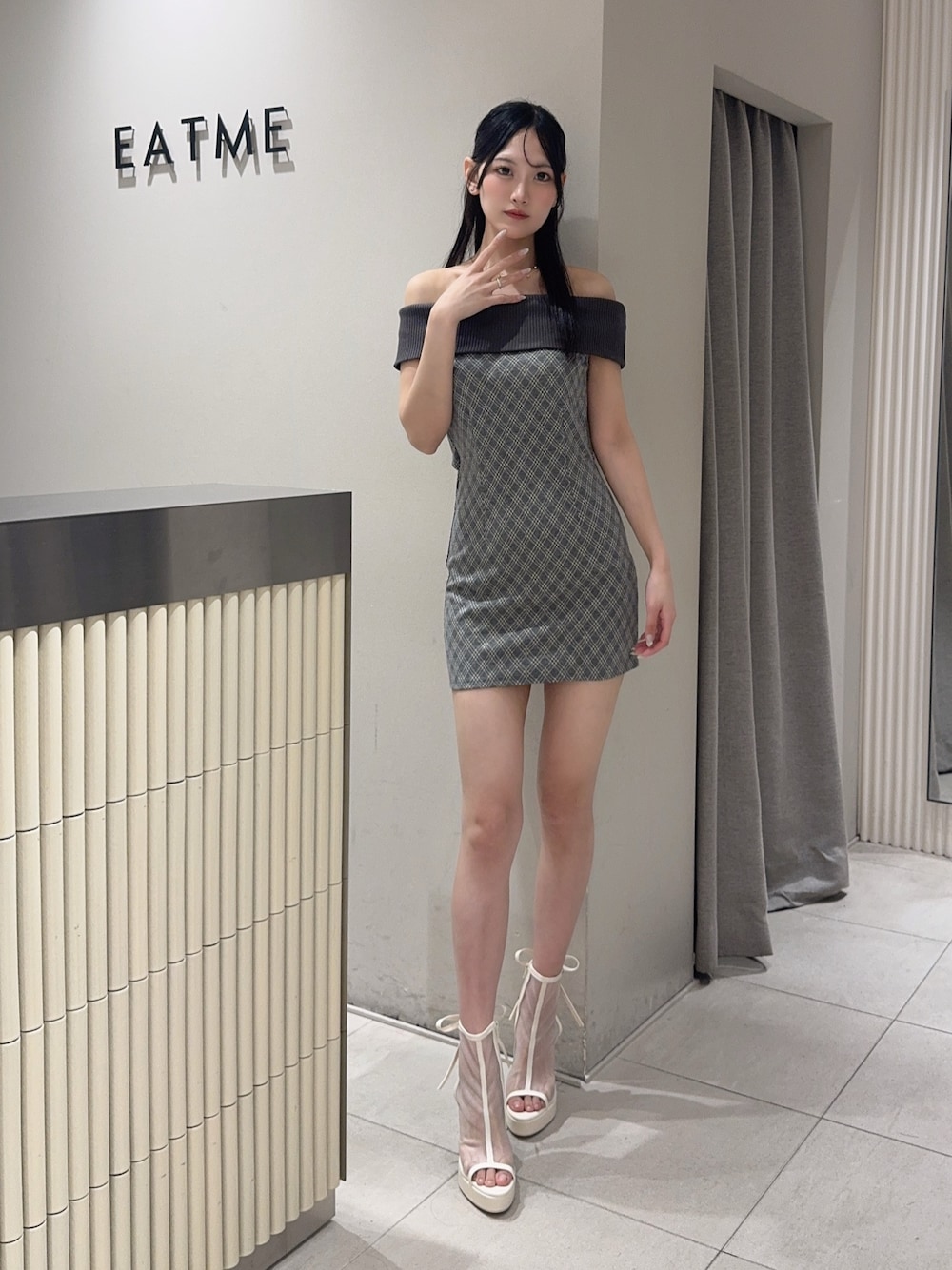 グレー系のワンピース、ホワイト系のサンダル、ゴールド系のネックレスを着用したレディースの夏コーディネートの1枚目の写真