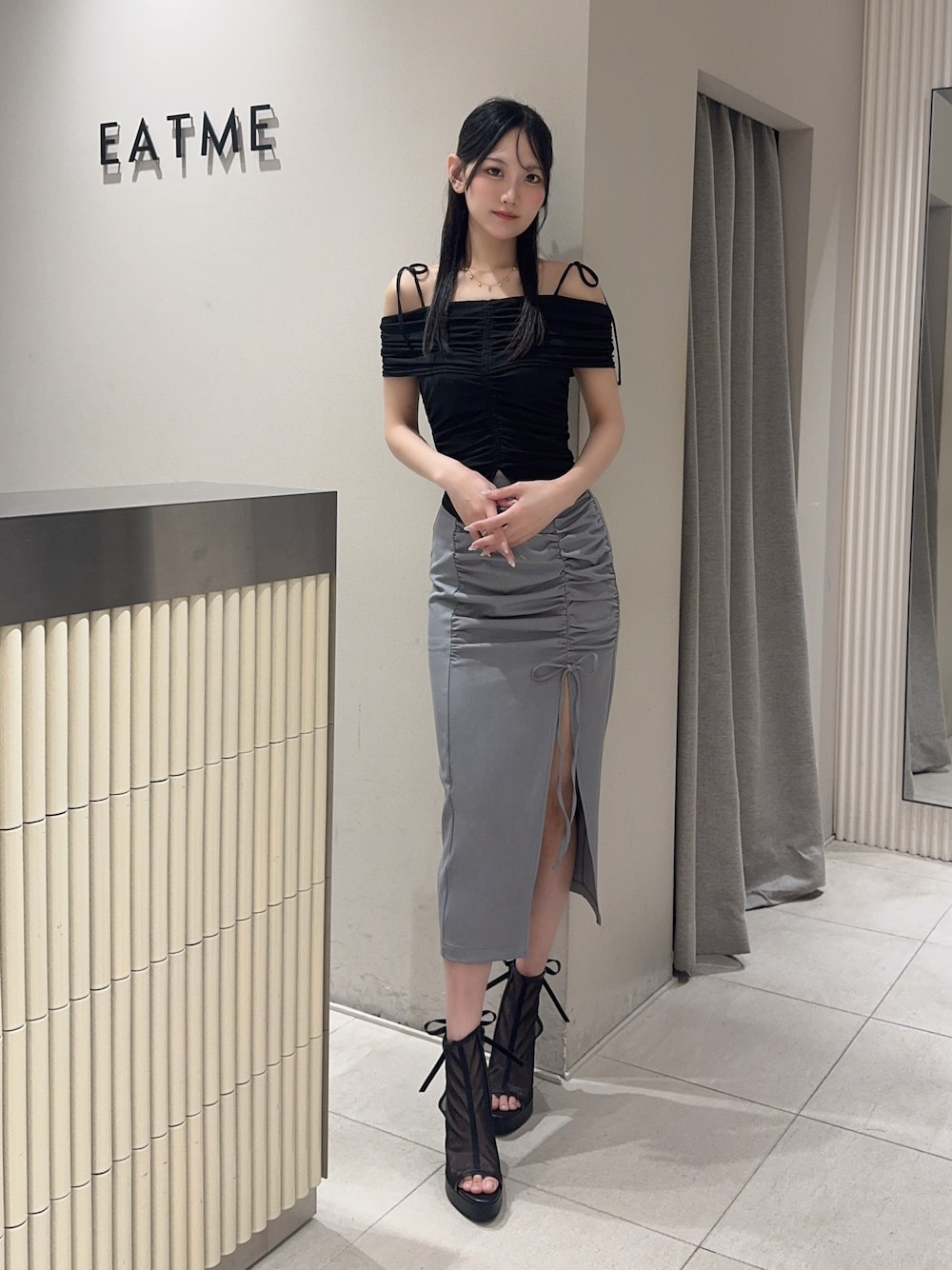 ブラック系のサンダル、グレー系のスカート、ブラック系のTシャツ/カットソーを着用したレディースの夏コーディネートの1枚目の写真