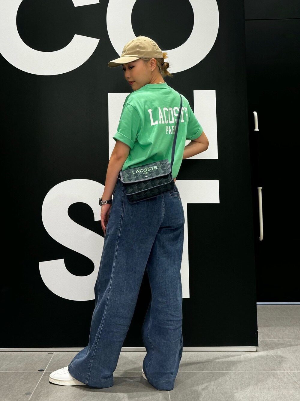 グリーン系のTシャツ/カットソー、ブルー系のデニムパンツ、ホワイト系のスニーカーを着用したレディースの夏コーディネートの1枚目の写真