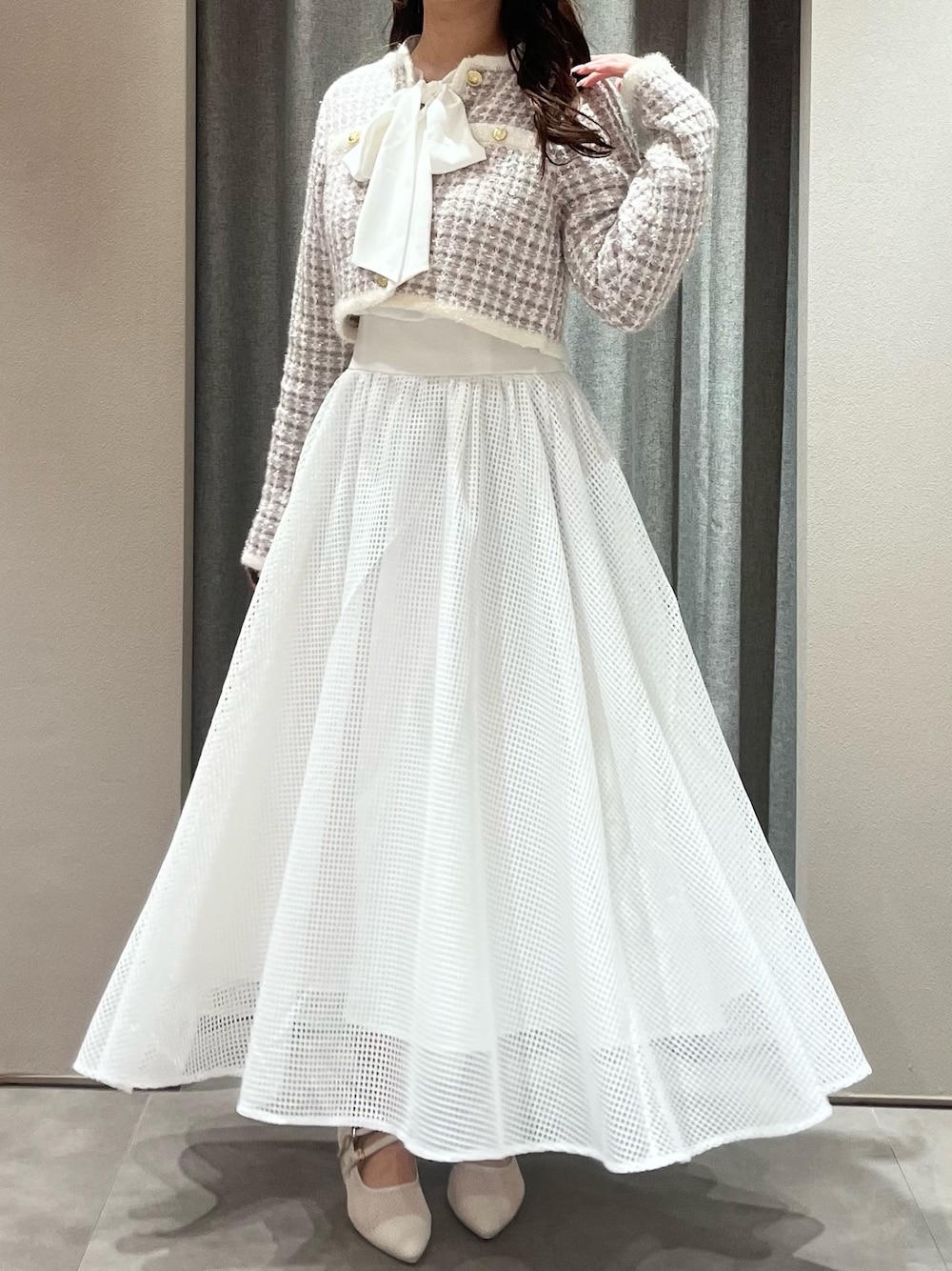 パープル系のノーカラージャケット、ホワイト系のワンピース、ホワイト系のパンプスを着用したレディースの春コーディネートの1枚目の写真