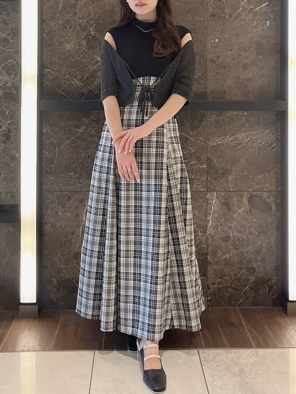 グレー系のニット/セーター、ブラック系のワンピース、ブラック系のパンプスを着用したレディースの夏コーディネートの1枚目の写真