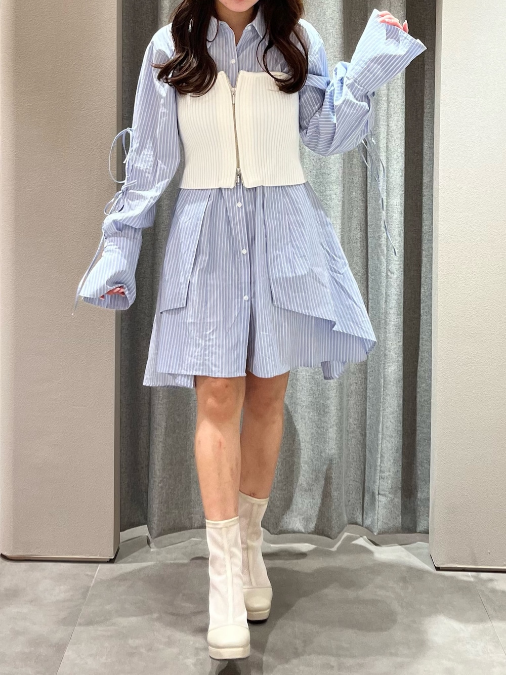 ホワイト系のキャミソール、ブルー系のシャツワンピース、ホワイト系のブーツを着用したレディースの冬コーディネートの1枚目の写真