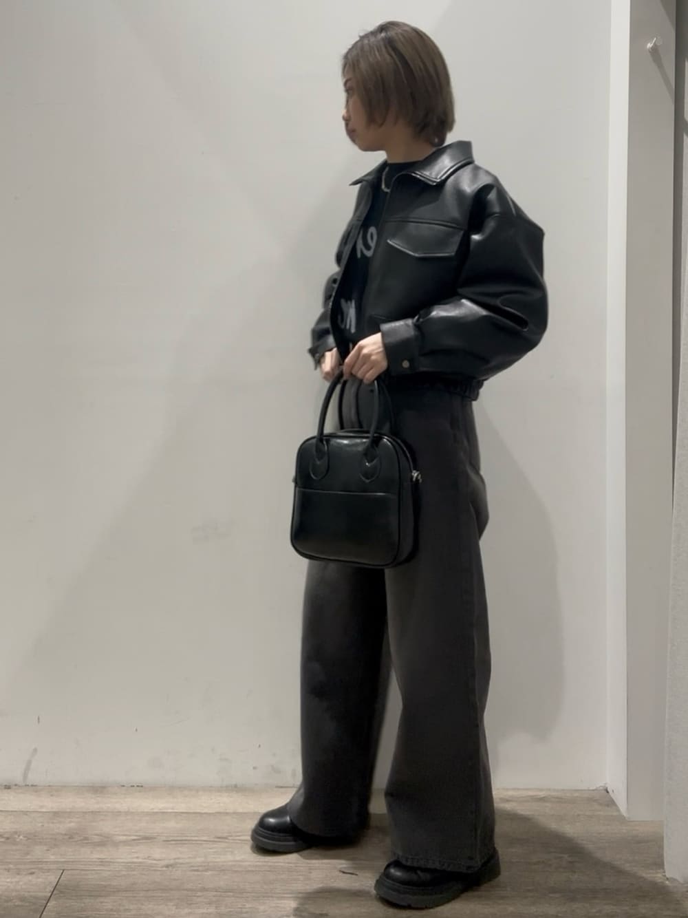 「レザージャケット、ショート丈、ショート丈ブルゾン、ワイドデニム、ワイドデニムパンツ、ブラックデニム、ブラックニット、ボストンバック、レザーブーツ 黒、レザーブーツ」｜「COLONY 2139のフェイクレザーショートブルゾン（ブルゾン、ブラック系）」を使った、tomooookaさん（骨格ウェーブ・レディース・157cm）の冬コーディネートの1枚目の写真