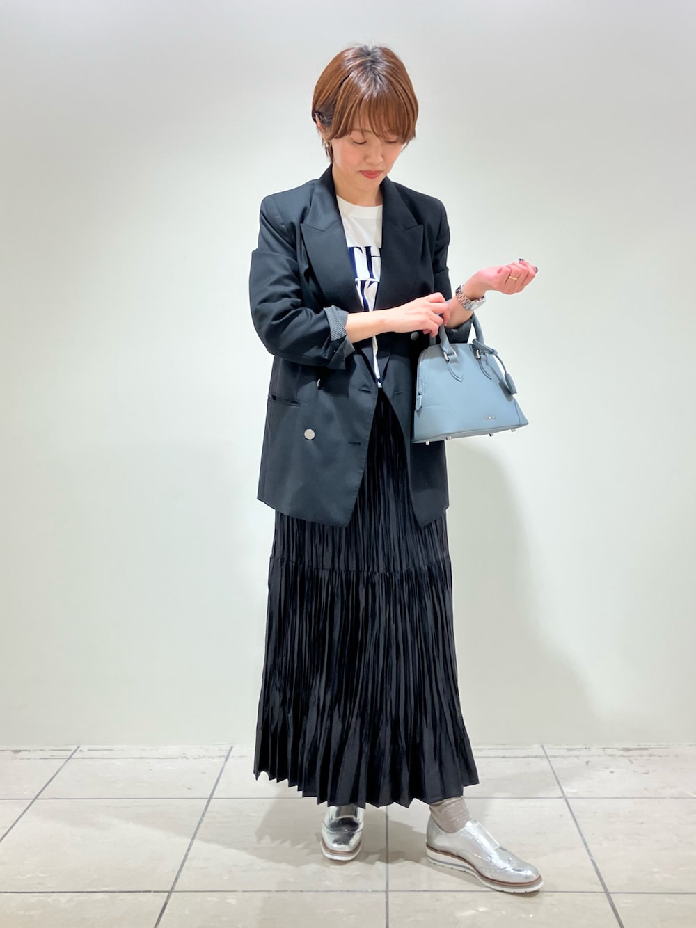 シルバー系のスリッポン、ブルー系のボストンバッグを着用したレディースの春コーディネートの1枚目の写真