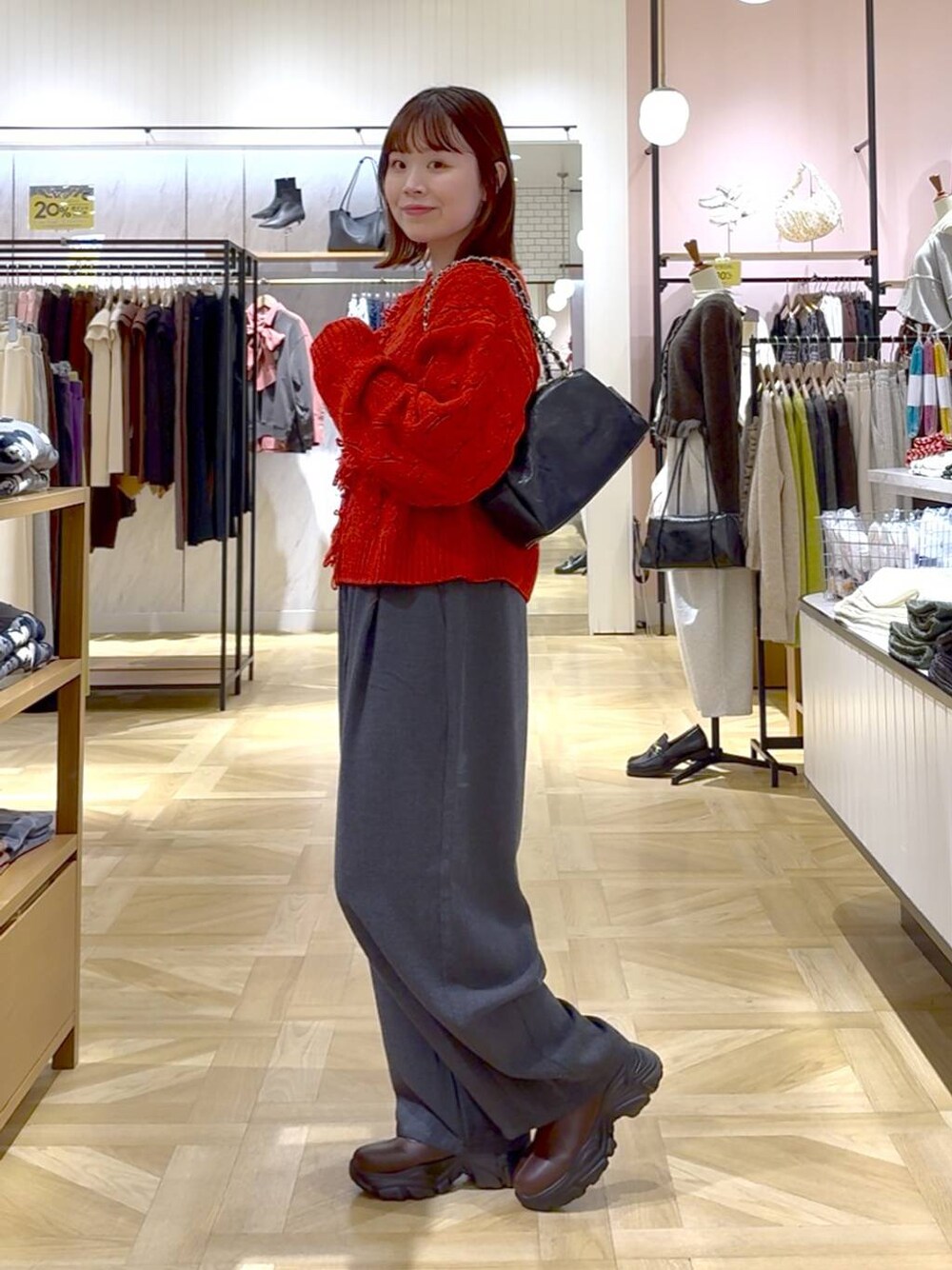 グレー系のその他パンツ、レッド系のポロシャツ、ブラック系のショルダーバッグを着用したレディースの秋コーディネートの1枚目の写真