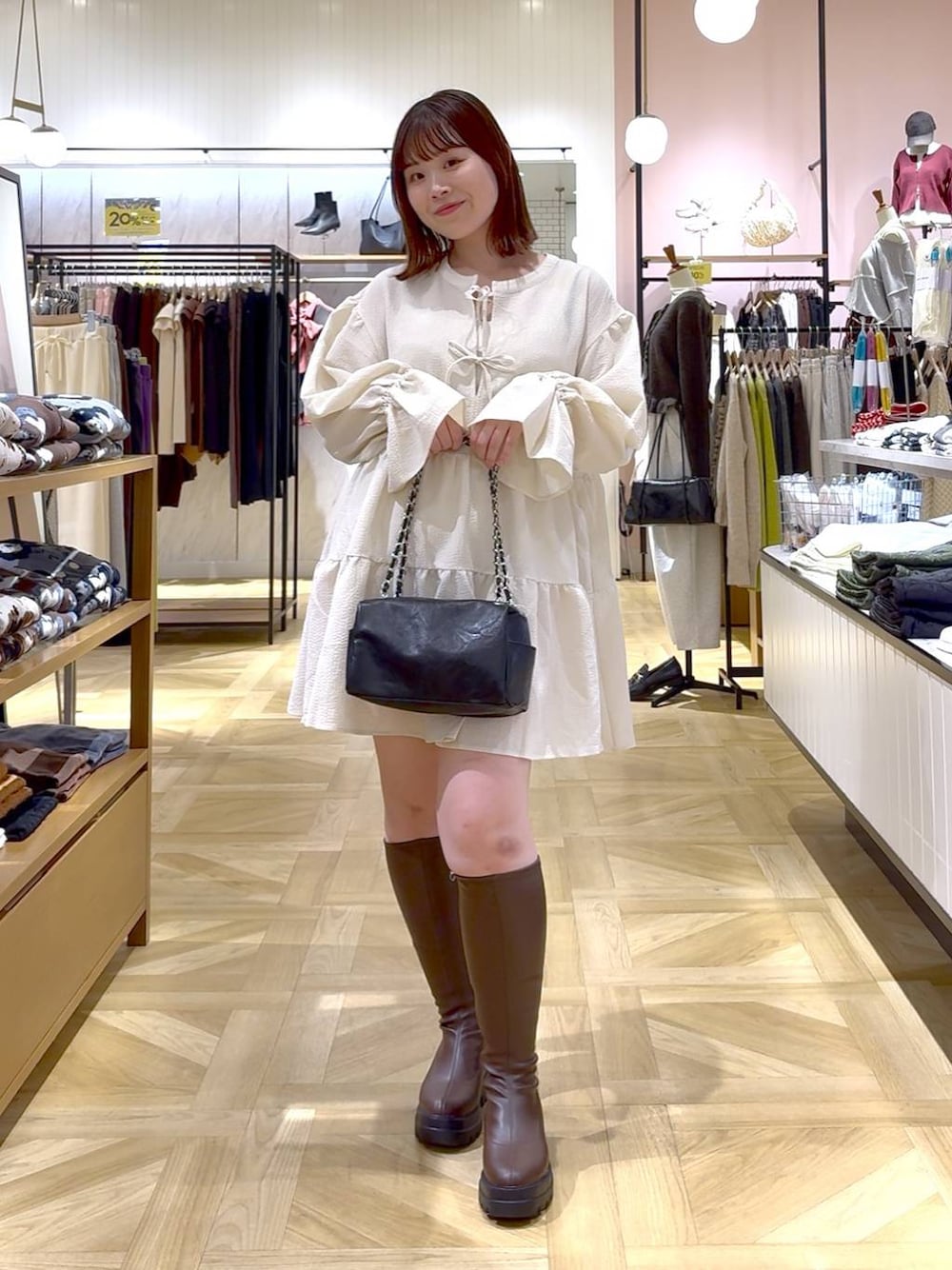 ホワイト系のタンクトップ、ブラウン系のブーツ、ホワイト系のワンピースを着用したレディースの秋コーディネートの1枚目の写真