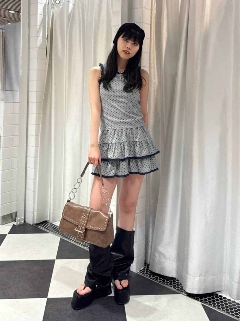 グレー系のタンクトップ、グレー系のスカート、ブラウン系のハンドバッグを着用したレディースの夏コーディネートの1枚目の写真