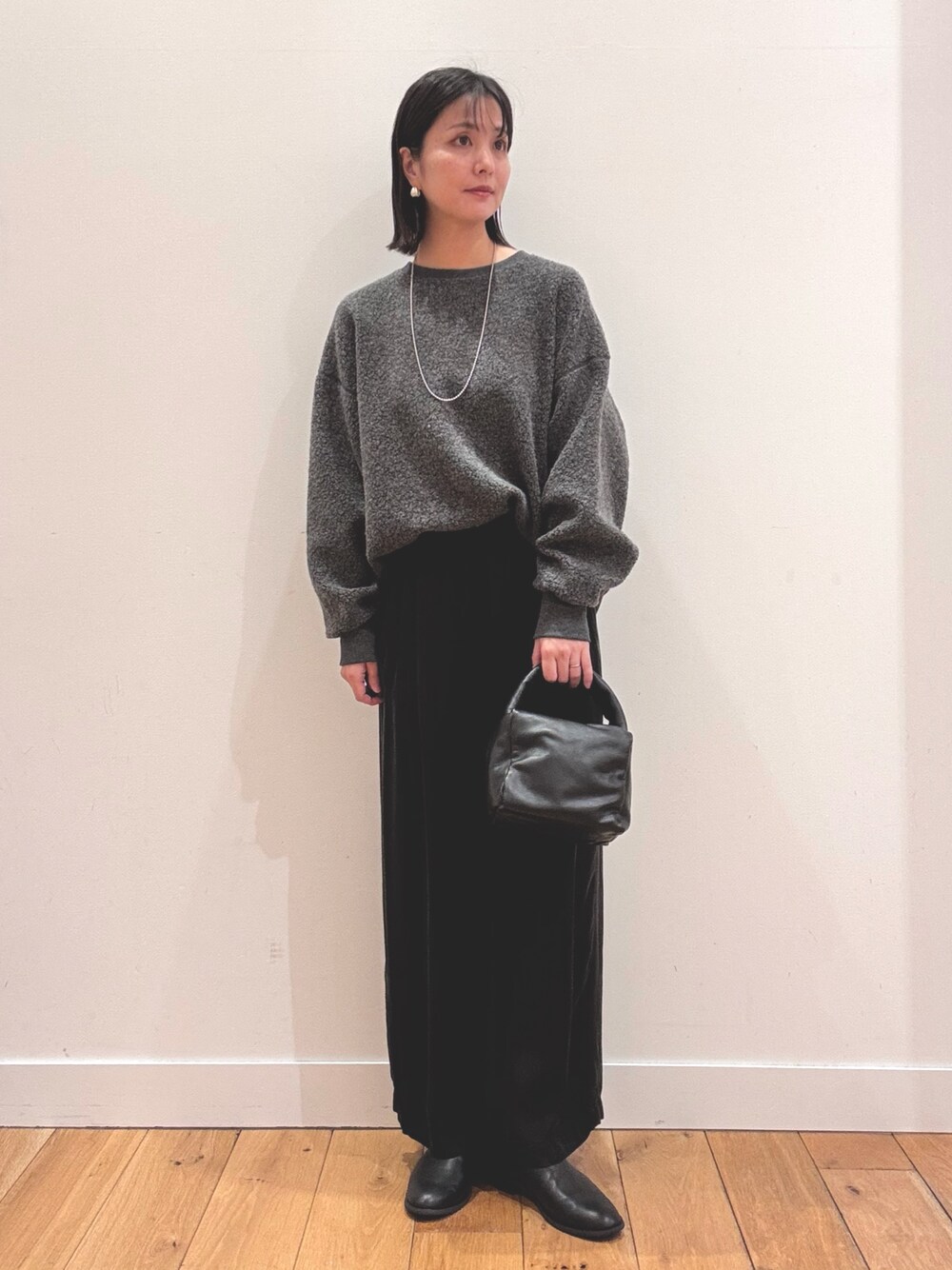 グレー系のその他トップス、ブラック系のその他パンツ、ブラック系のハンドバッグを着用したレディースの秋コーディネートの1枚目の写真
