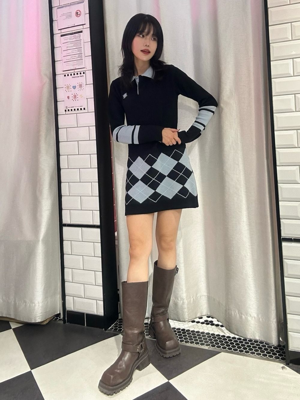 ブラック系のワンピース、ブラウン系のブーツを着用したレディースの冬コーディネートの1枚目の写真