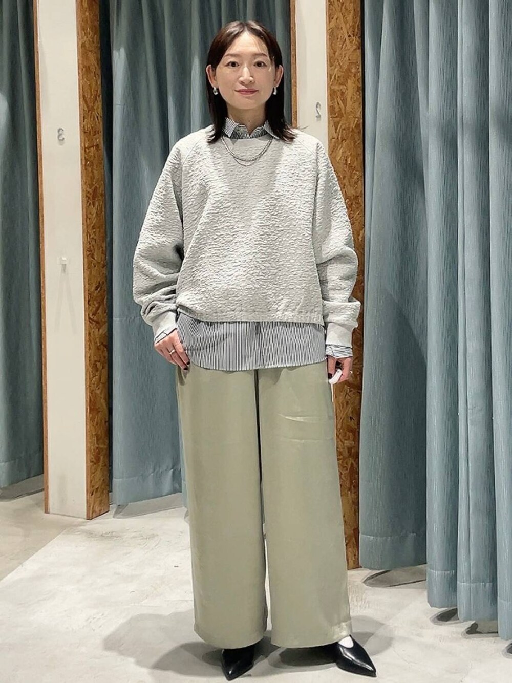 グレー系のシャツ/ブラウス、ブラック系のパンプス、グリーン系のその他パンツを着用したレディースの秋コーディネートの1枚目の写真