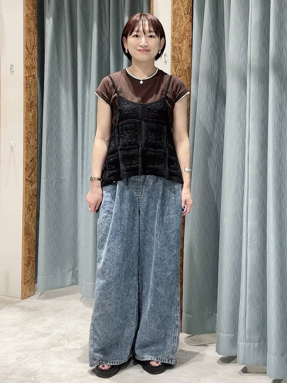 ブルー系のデニムパンツ、ブラック系のキャミソール、ブラック系のサンダルを着用したレディースの夏コーディネートの1枚目の写真