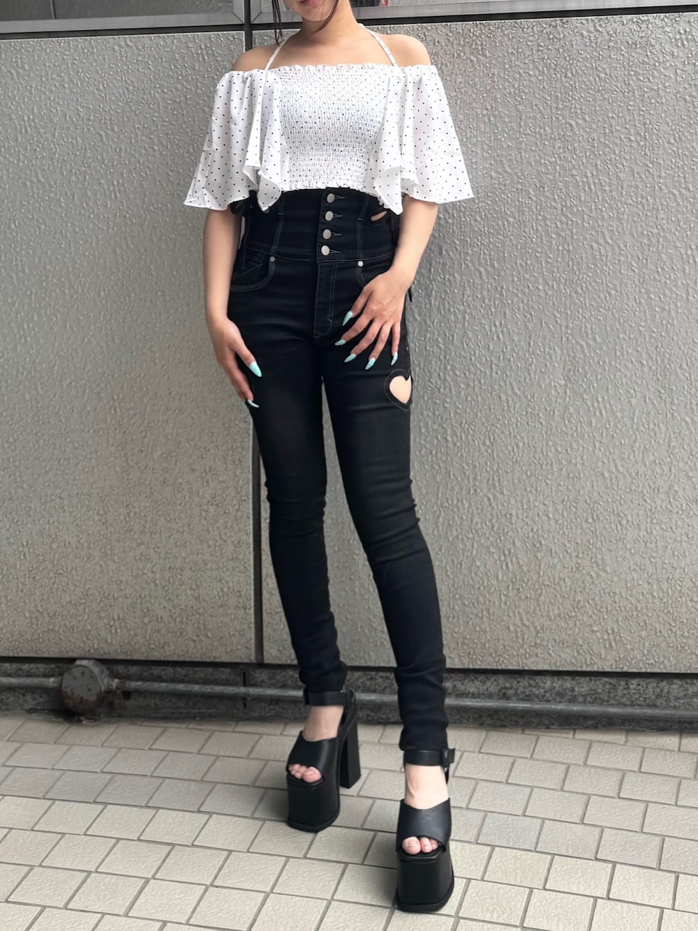 ブラック系のデニムパンツ、ホワイト系のTシャツ/カットソー、ブラック系のサンダルを着用したレディースの夏コーディネートの1枚目の写真