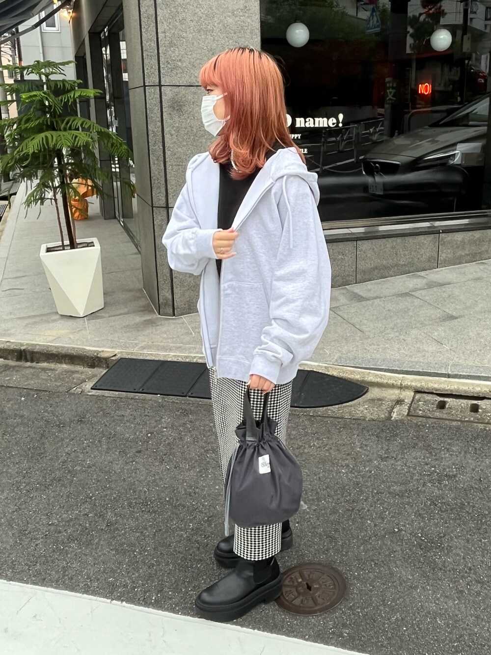 シルバー系のパーカー、ブラック系のTシャツ/カットソー、ブラック系のハンドバッグを着用したレディースの秋コーディネートの1枚目の写真