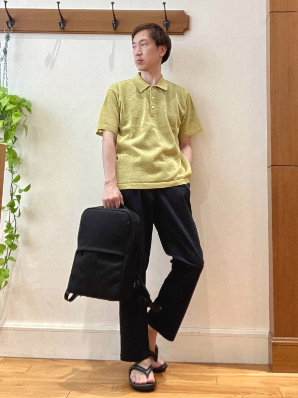 イエロー系のニット/セーター、ブルー系のその他パンツ、ブラック系のバックパック/リュックを着用したメンズの春コーディネートの1枚目の写真