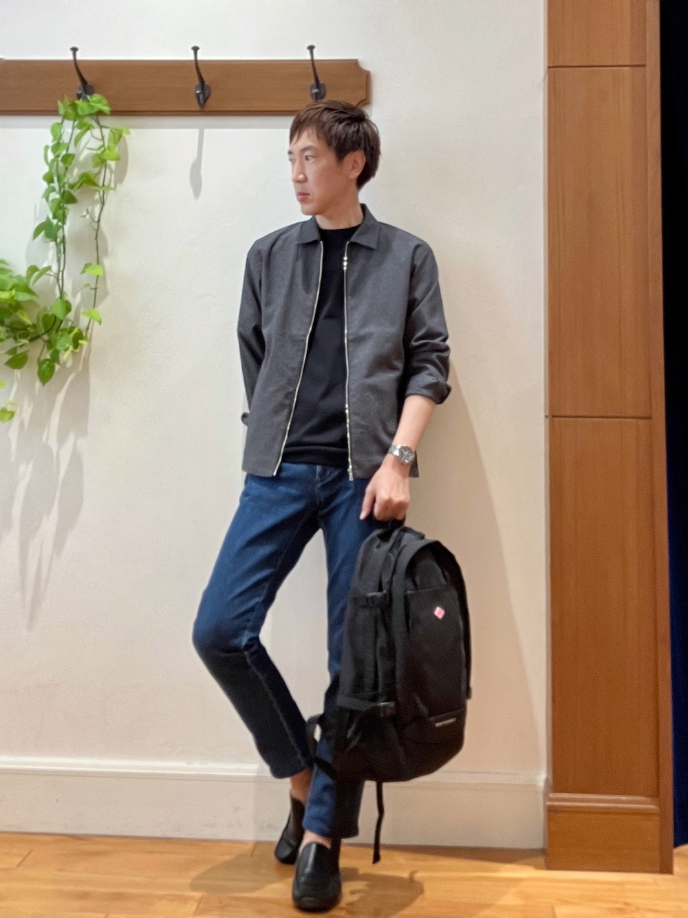 ブラック系のバックパック/リュック、ブルー系のデニムパンツ、ブラック系のTシャツ/カットソーを着用したメンズの夏コーディネートの1枚目の写真
