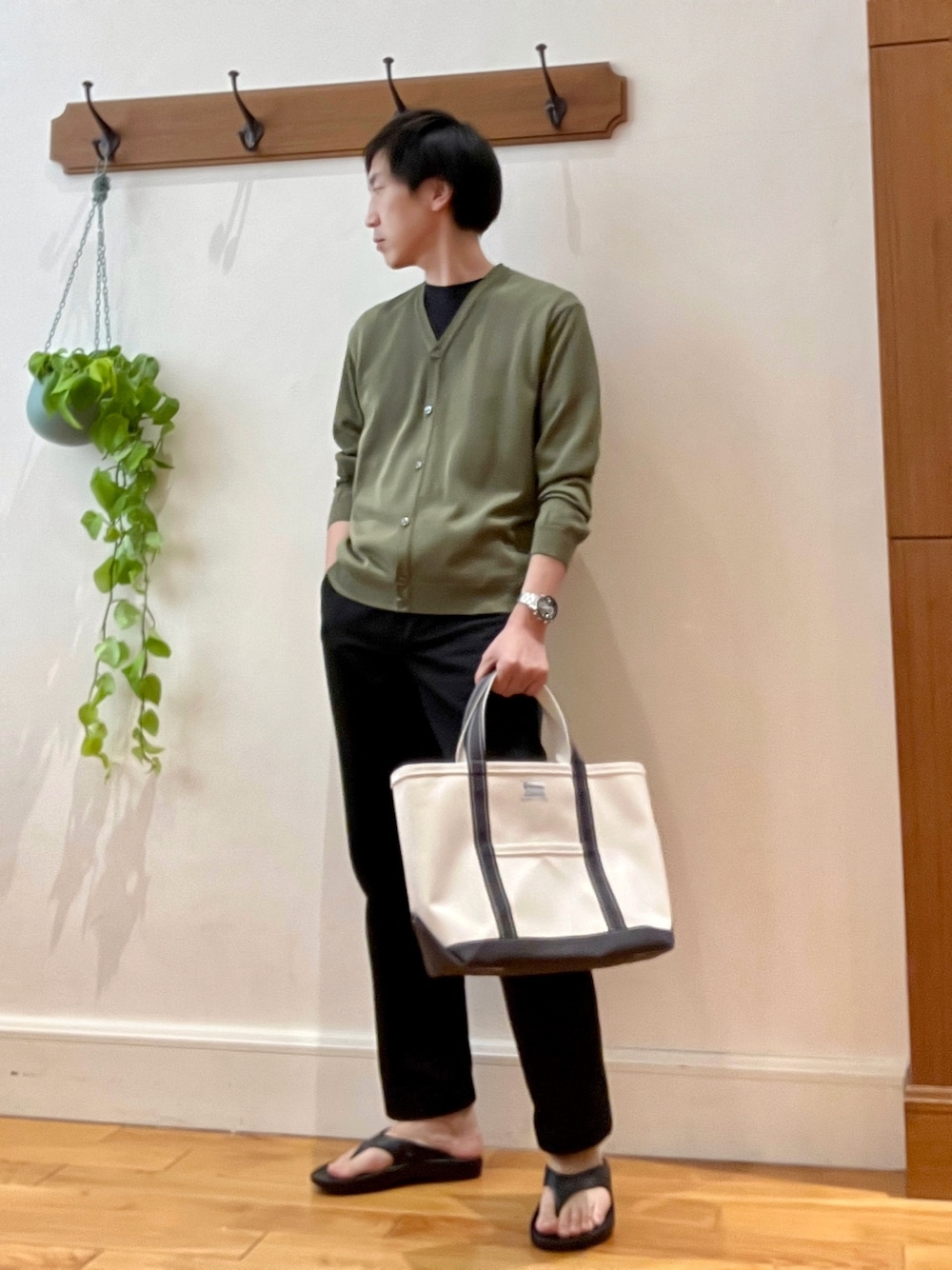 グリーン系のカーディガン/ボレロ、ブラック系のサンダル、ホワイト系のトートバッグを着用したメンズの春コーディネートの1枚目の写真