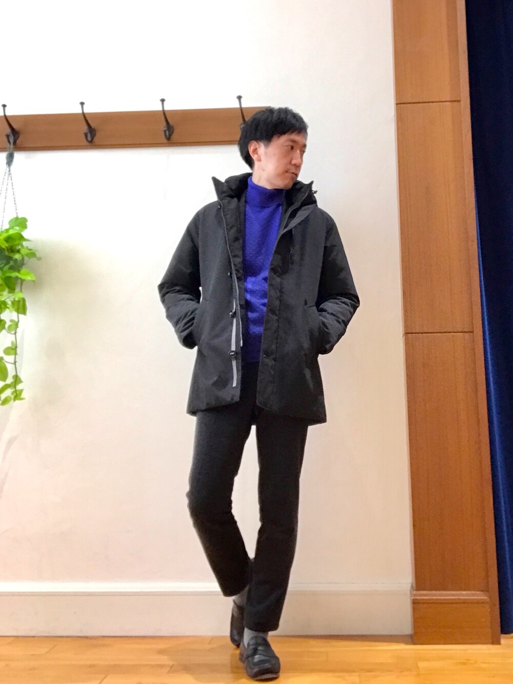 ブラック系のダウンジャケット/コート、ブルー系のニット/セーター、グレー系のその他パンツを着用したメンズの冬コーディネートの1枚目の写真
