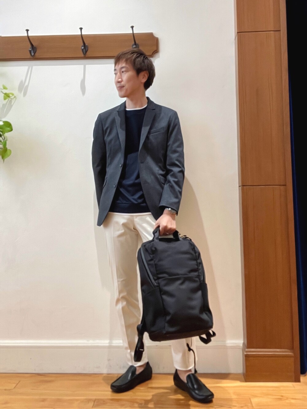 ホワイト系のチノパンツ、ブラック系のバックパック/リュック、ブルー系のテーラードジャケットを着用したメンズの秋コーディネートの1枚目の写真