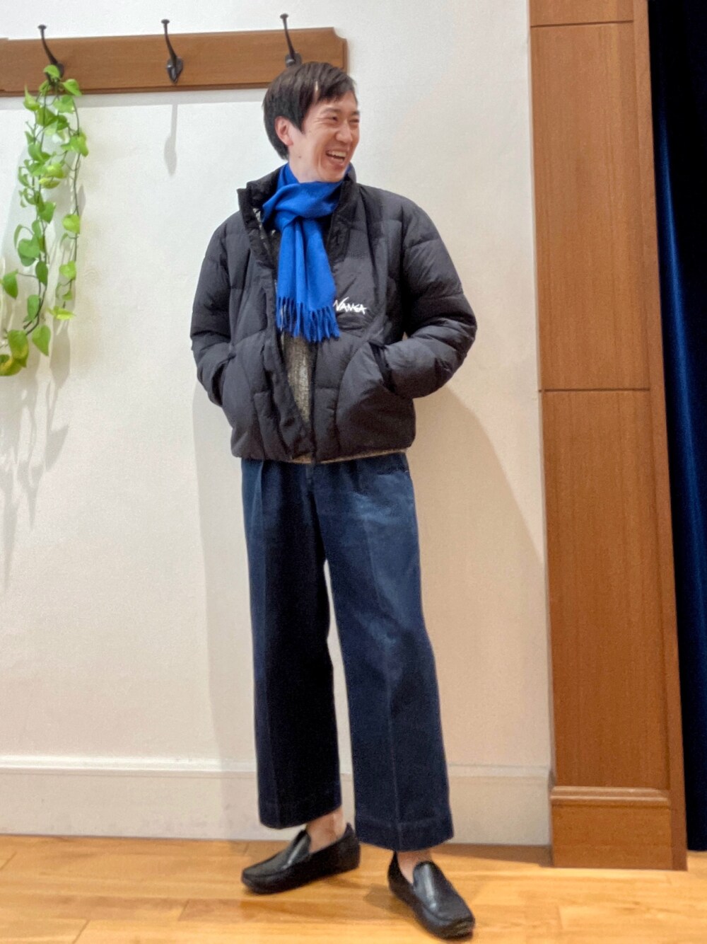 グリーン系のダウンジャケット/コート、ブルー系のニット/セーター、ブルー系のマフラーを着用したメンズの秋コーディネートの1枚目の写真