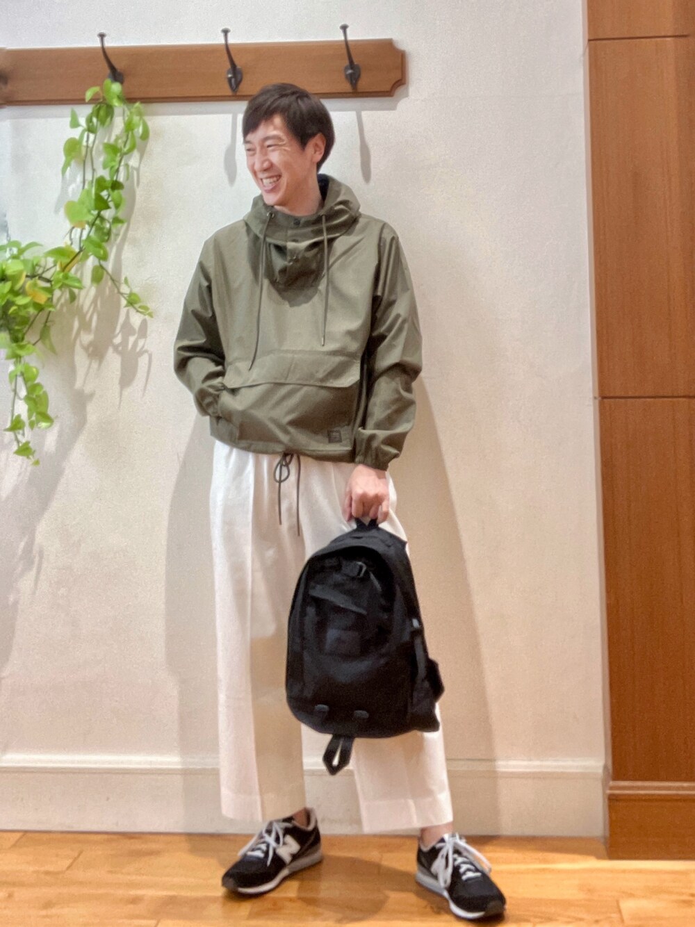 ホワイト系のデニムパンツ、ブラック系のバックパック/リュック、グリーン系のブルゾンを着用したメンズの冬コーディネートの1枚目の写真