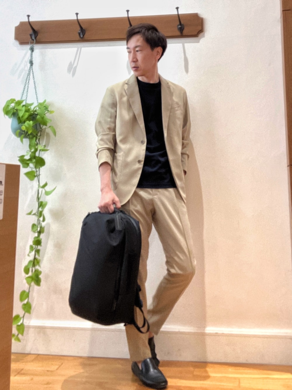 ベージュ系のテーラードジャケット、ブルー系のTシャツ/カットソー、ブラック系のバックパック/リュックを着用したメンズの春コーディネートの1枚目の写真