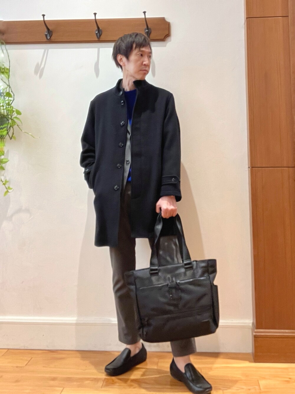 ブラック系のその他アウター、ブルー系のニット/セーター、グレー系のテーラードジャケットを着用したメンズの秋コーディネートの1枚目の写真
