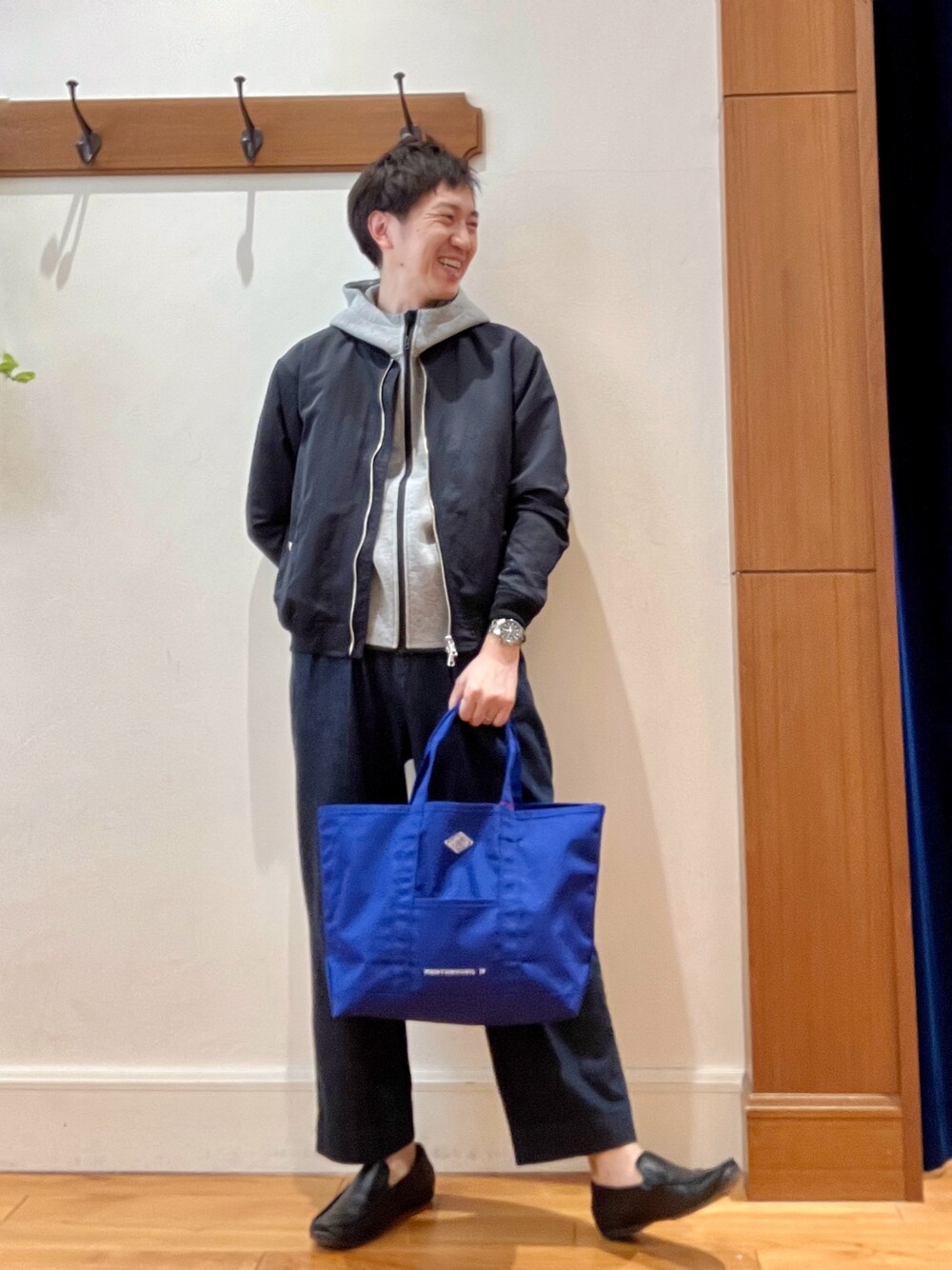 ブラック系のブルゾン、グレー系のパーカー、ブルー系のデニムパンツを着用したメンズの春コーディネートの1枚目の写真