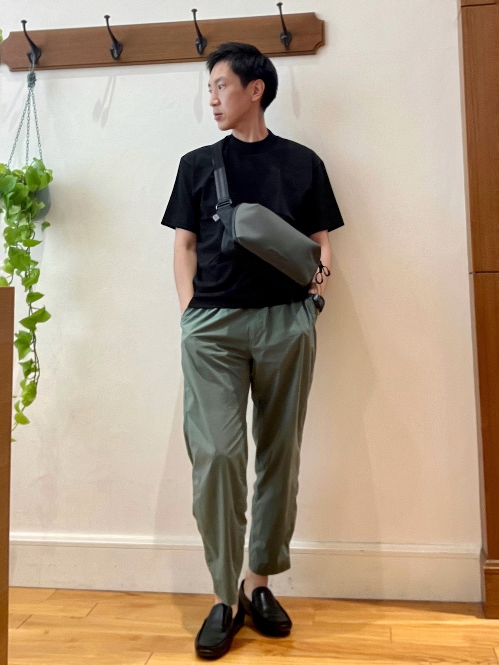 ブラック系のTシャツ/カットソー、グリーン系のショルダーバッグを着用したメンズの夏コーディネートの1枚目の写真