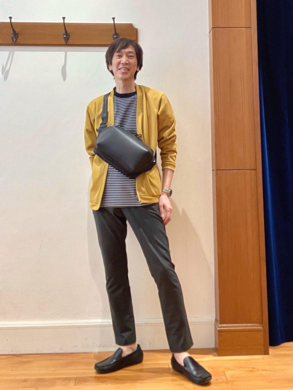 イエロー系のカーディガン/ボレロ、ブラック系のTシャツ/カットソー、ブラック系のショルダーバッグを着用したメンズの春コーディネートの1枚目の写真