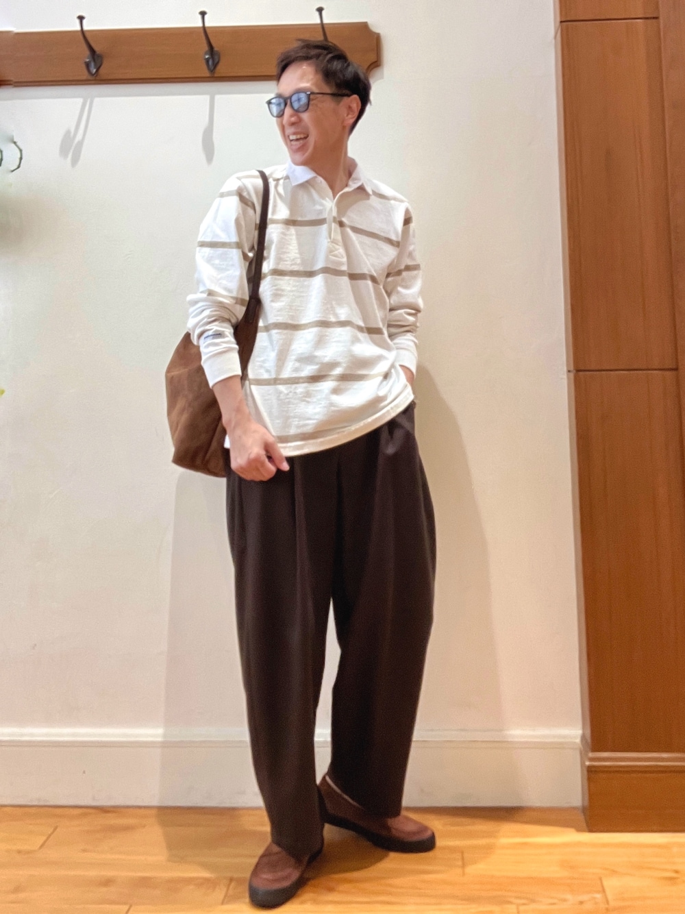 イエロー系のショルダーバッグ、ブラウン系のスニーカー、ホワイト系のTシャツ/カットソーを着用したメンズの秋コーディネートの1枚目の写真