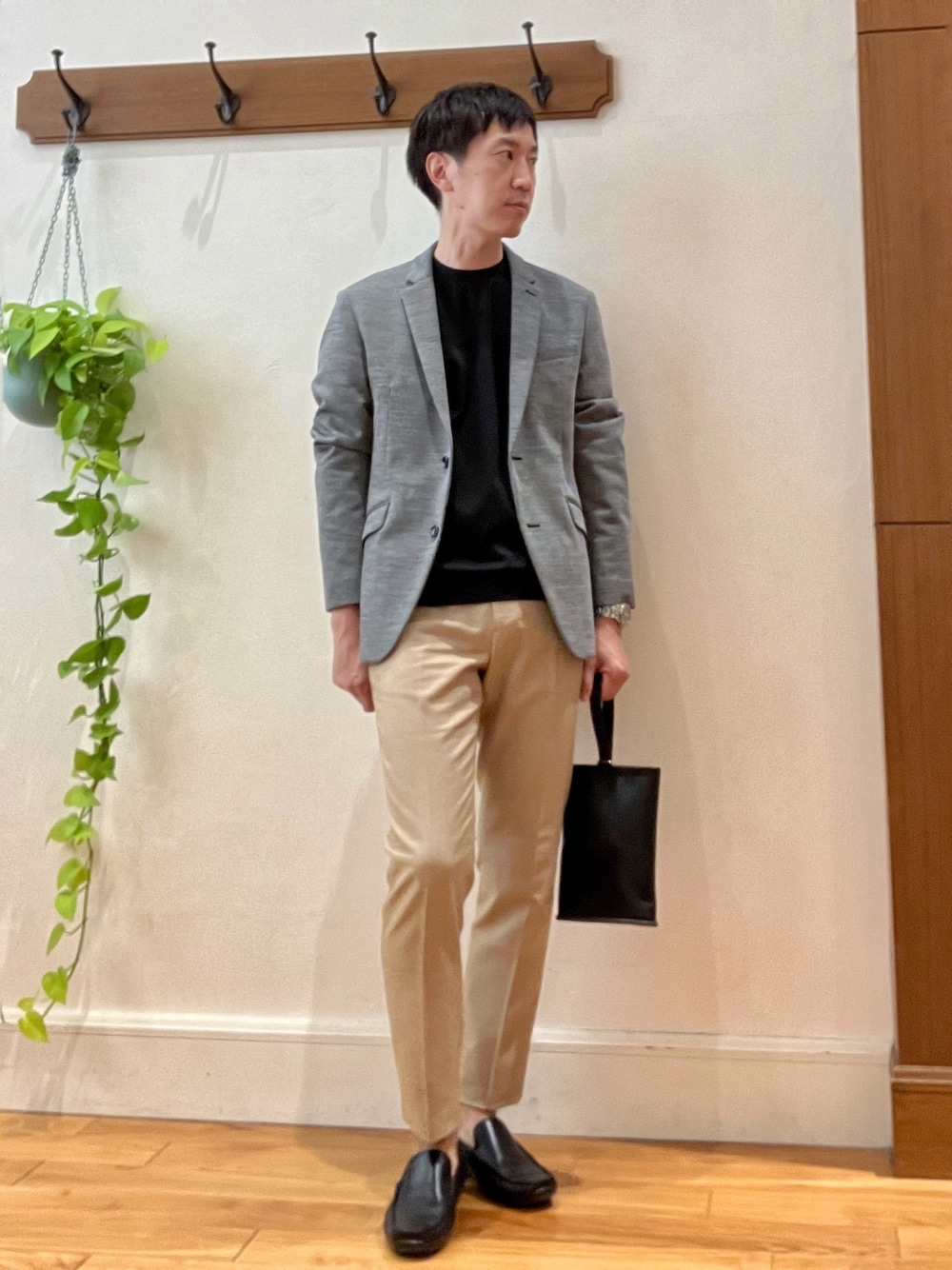 グレー系のテーラードジャケット、ブラック系のTシャツ/カットソー、ブラック系のハンドバッグを着用したメンズの秋コーディネートの1枚目の写真