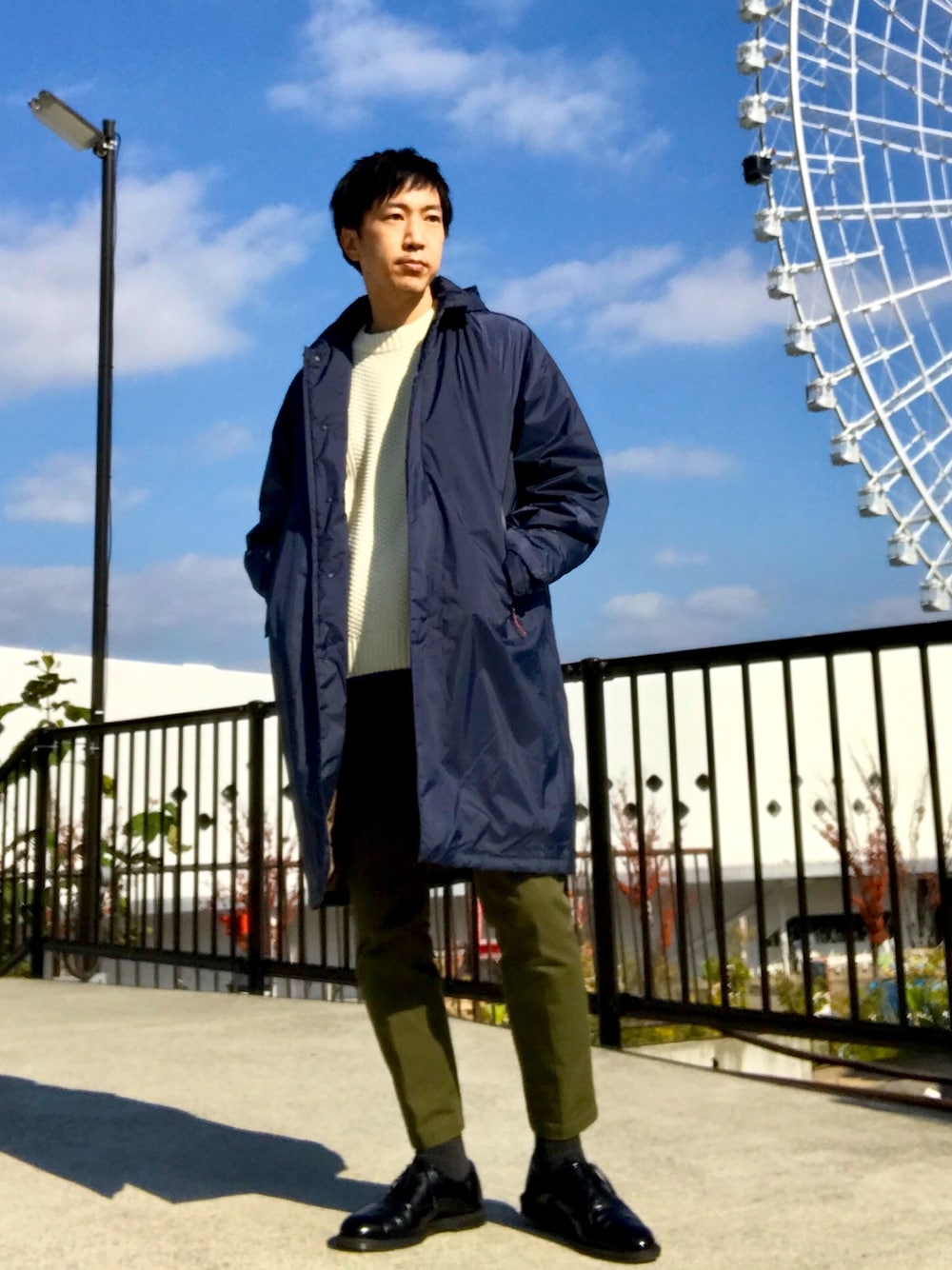 ブルー系のダウンジャケット/コート、ホワイト系のニット/セーター、グリーン系のチノパンツを着用したメンズの冬コーディネートの1枚目の写真