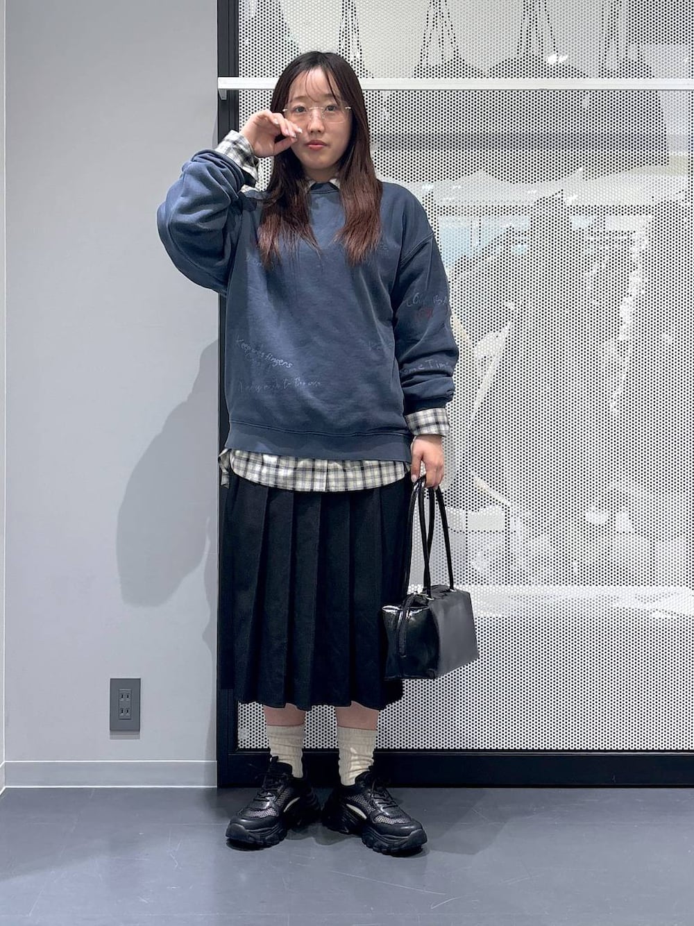 ブラック系のスカート、ブラック系のスニーカー、ベージュ系のシャツ/ブラウスを着用したレディースの冬コーディネートの1枚目の写真