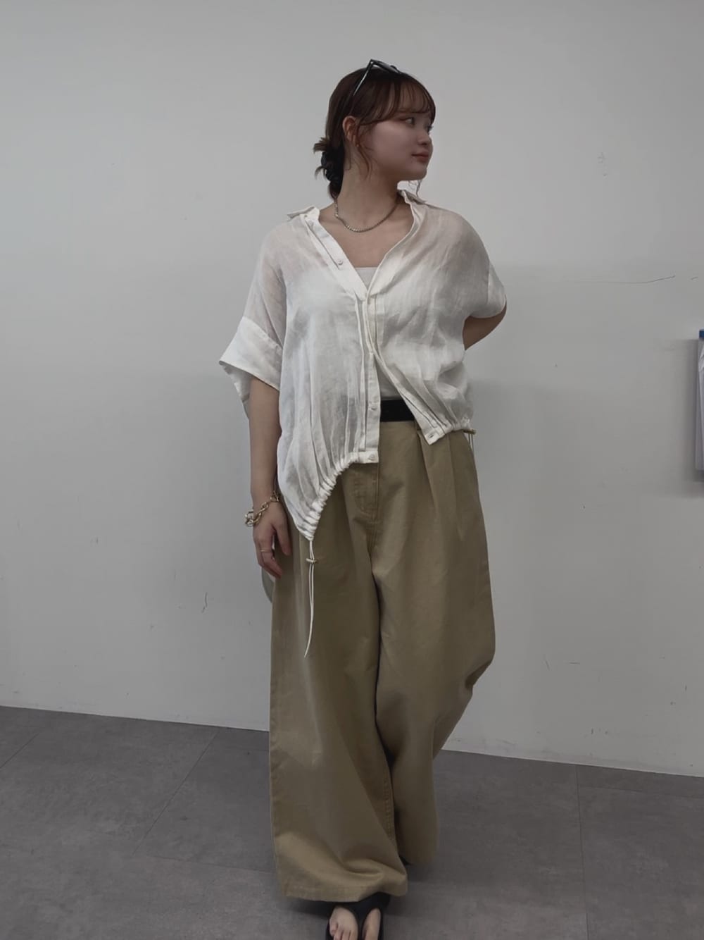 ホワイト系のシャツ/ブラウス、ベージュ系のチノパンツを着用したレディースの夏コーディネートの1枚目の写真