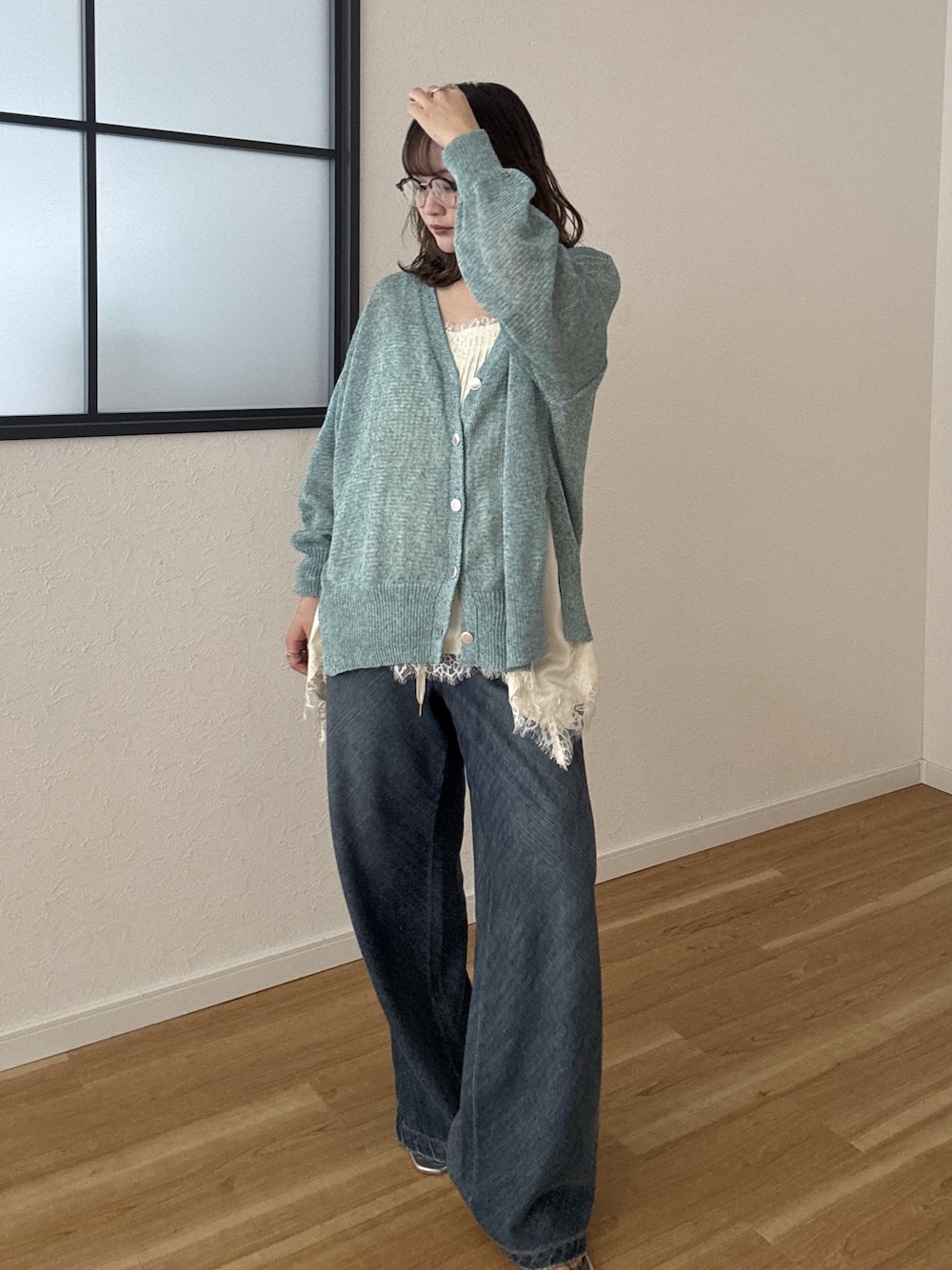 グリーン系のカーディガン/ボレロ、ブルー系のデニムパンツを着用したレディースの春コーディネートの1枚目の写真