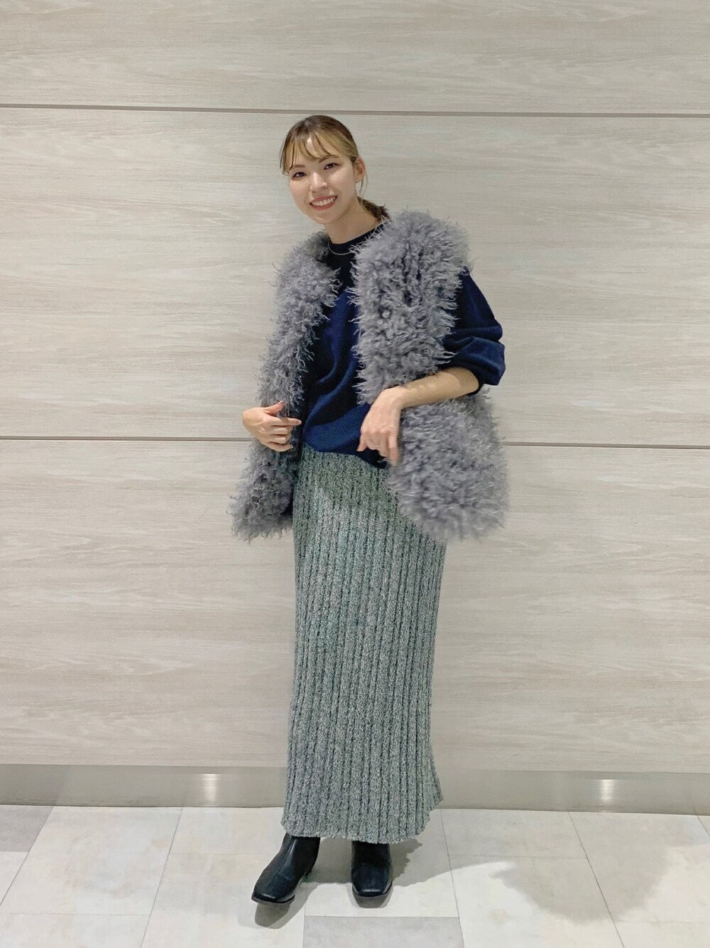ブラック系のブーツ、グリーン系のスカート、ブルー系のスウェットを着用したレディースの秋コーディネートの1枚目の写真