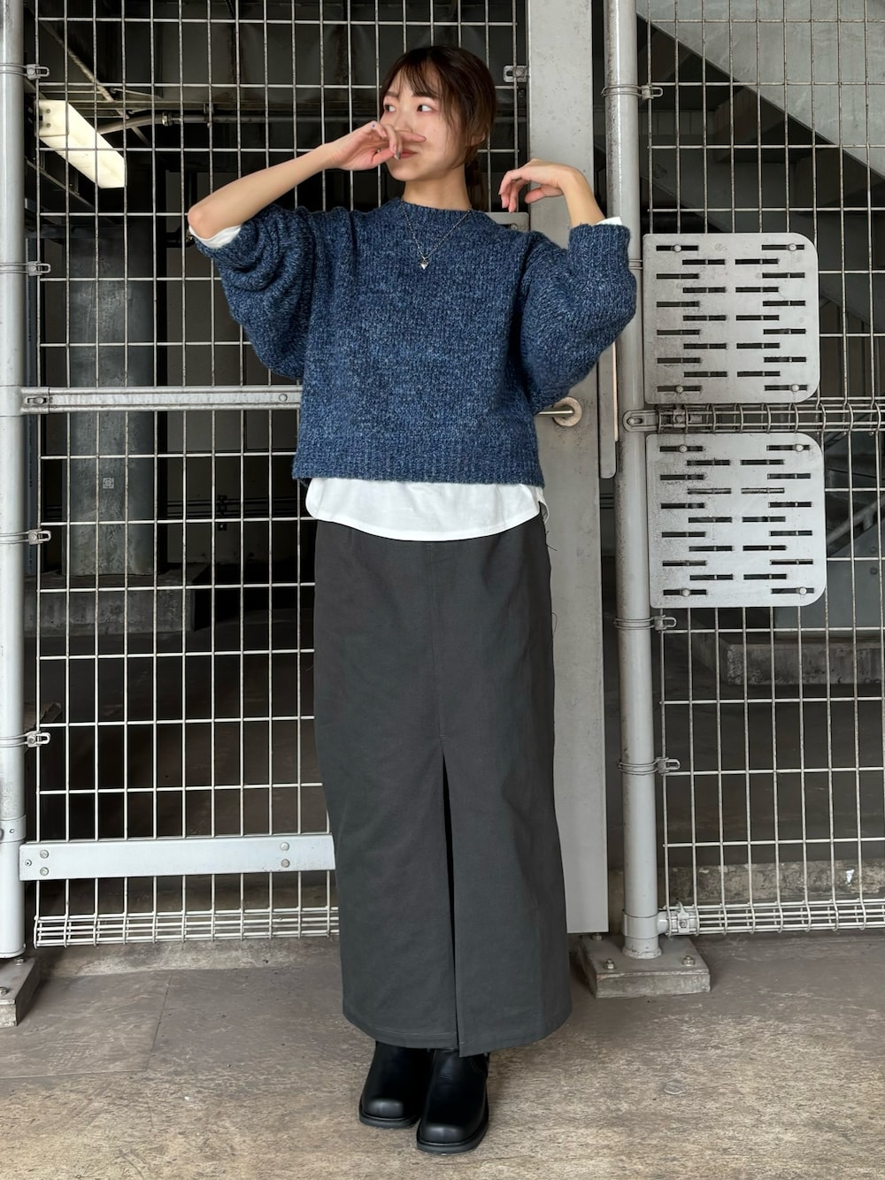 ブラック系のブーツ、ブルー系のニット/セーター、ホワイト系のTシャツ/カットソーを着用したレディースの秋コーディネートの1枚目の写真