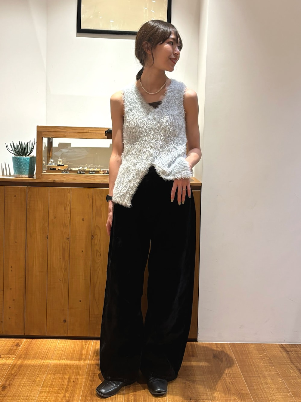 ブラック系のデニムパンツ、シルバー系のニット/セーターを着用したレディースの夏コーディネートの1枚目の写真