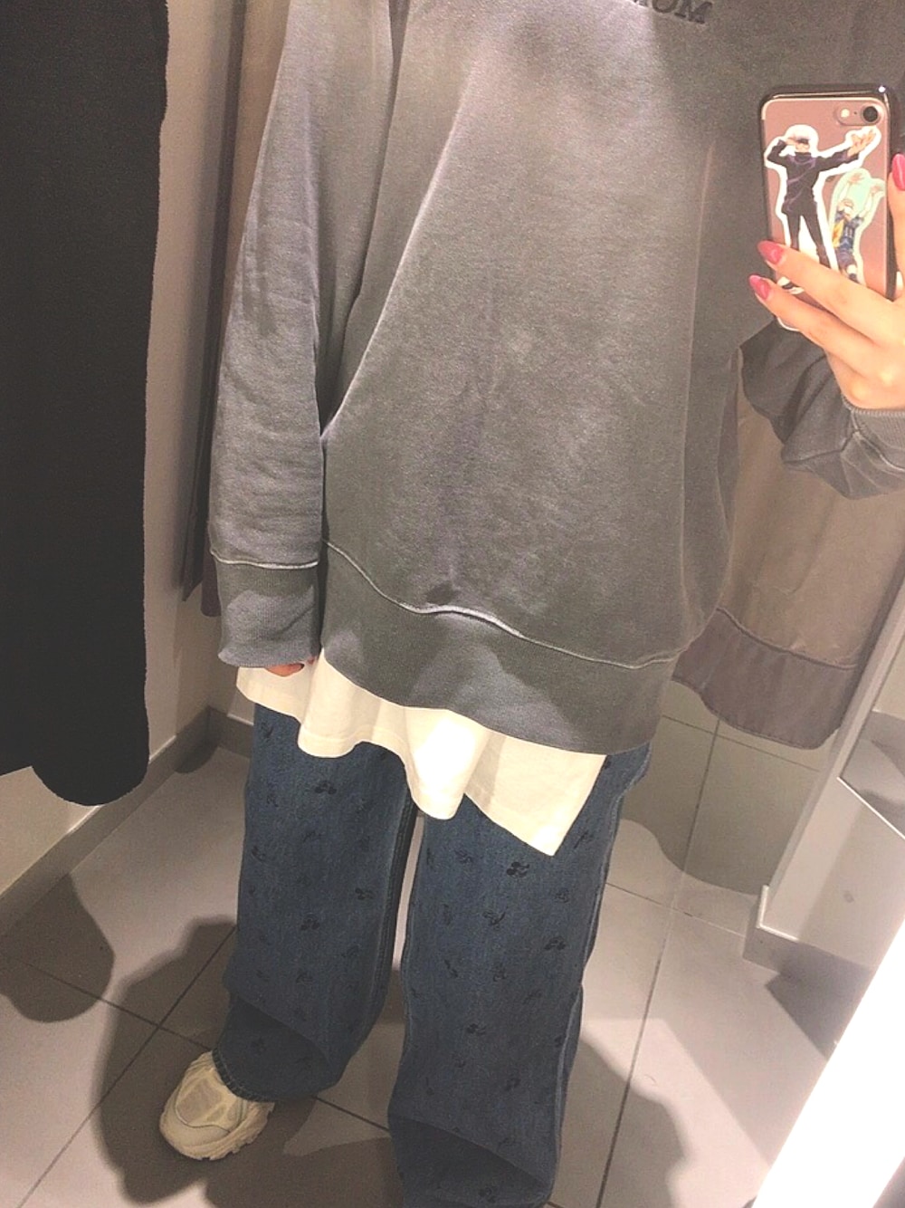 ホワイト系のスニーカー、ブルー系のデニムパンツ、ブラック系のスウェットを着用したレディースの冬コーディネートの1枚目の写真