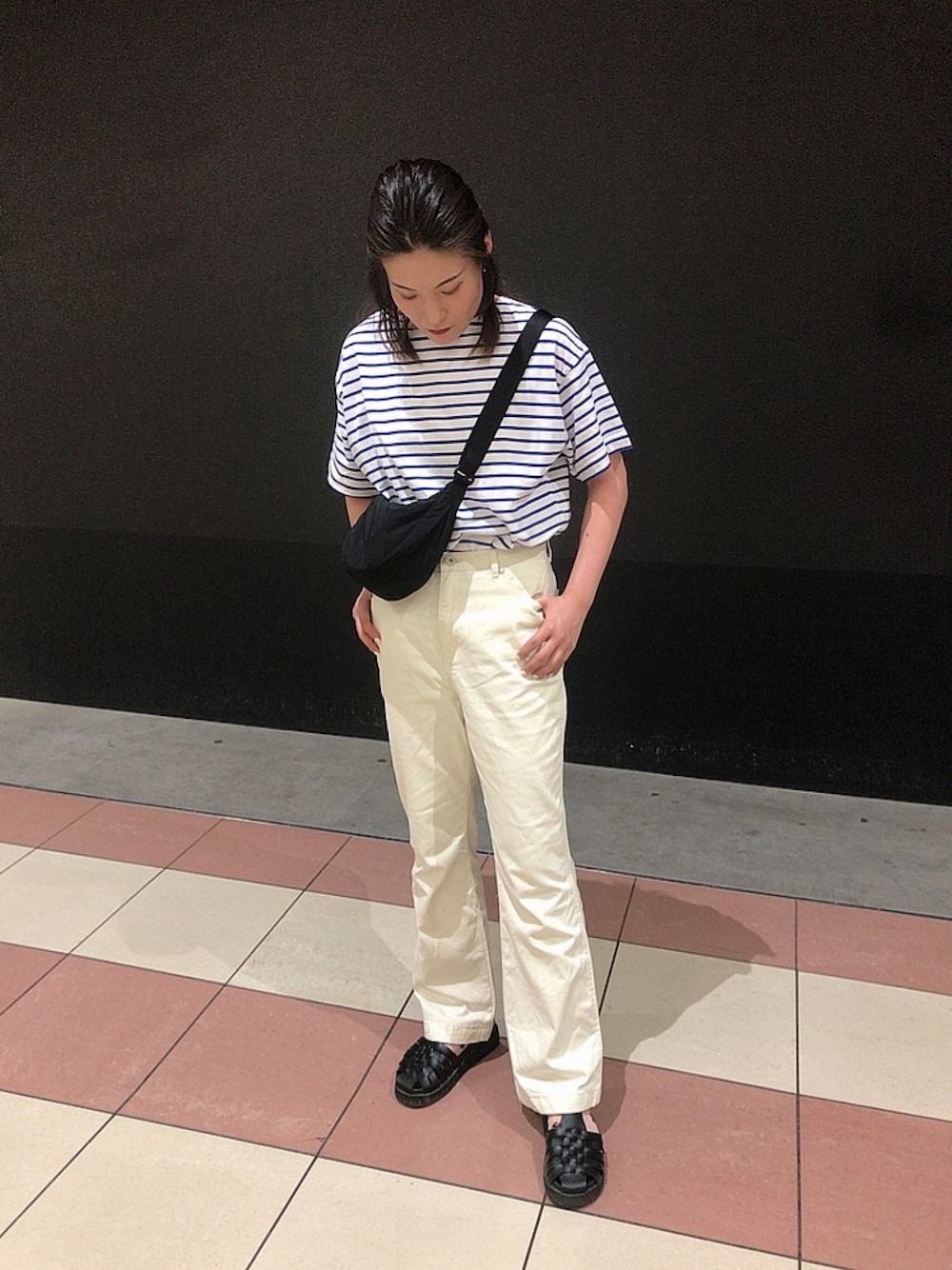 ブラック系のサンダル、ホワイト系のデニムパンツ、ブラック系のバッグを着用したレディースの夏コーディネートの1枚目の写真