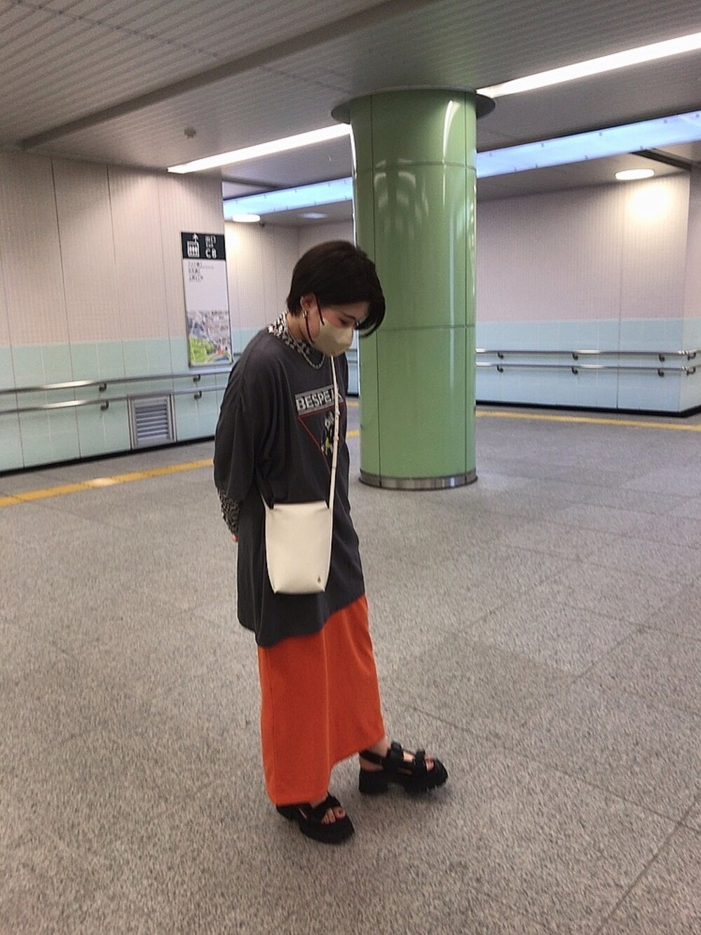 ブラック系のサンダル、オレンジ系のスカート、ホワイト系のショルダーバッグを着用したレディースの夏コーディネートの1枚目の写真